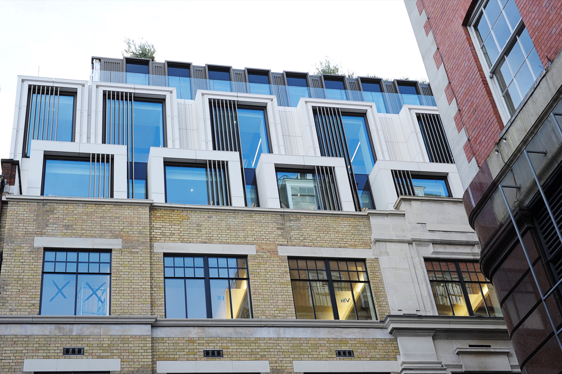 Axtell House, Warwick Street, Soho — a restored commercial office envelope with an engineered-stone and glazed rooftop extension above the retained masonry base.