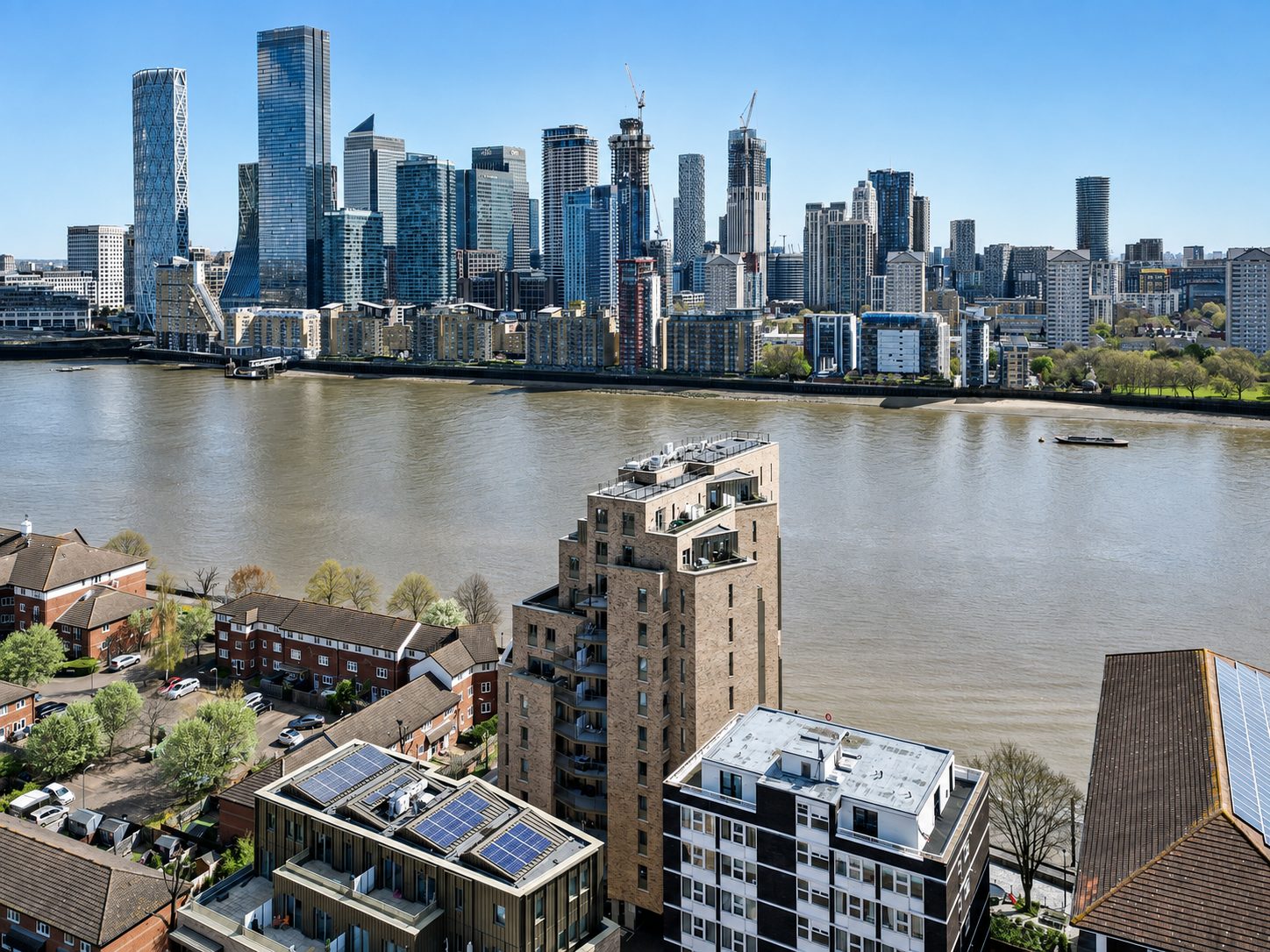 Imperial Court's stepped brick tower on the Thames at Rotherhithe, with Canary Wharf across the river