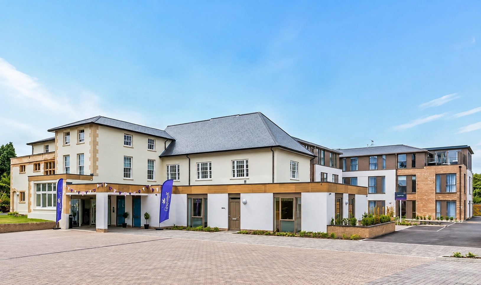 The entrance court of Liberham Lodge, with the rendered retained house, the single-storey entrance range and the new wing to the right