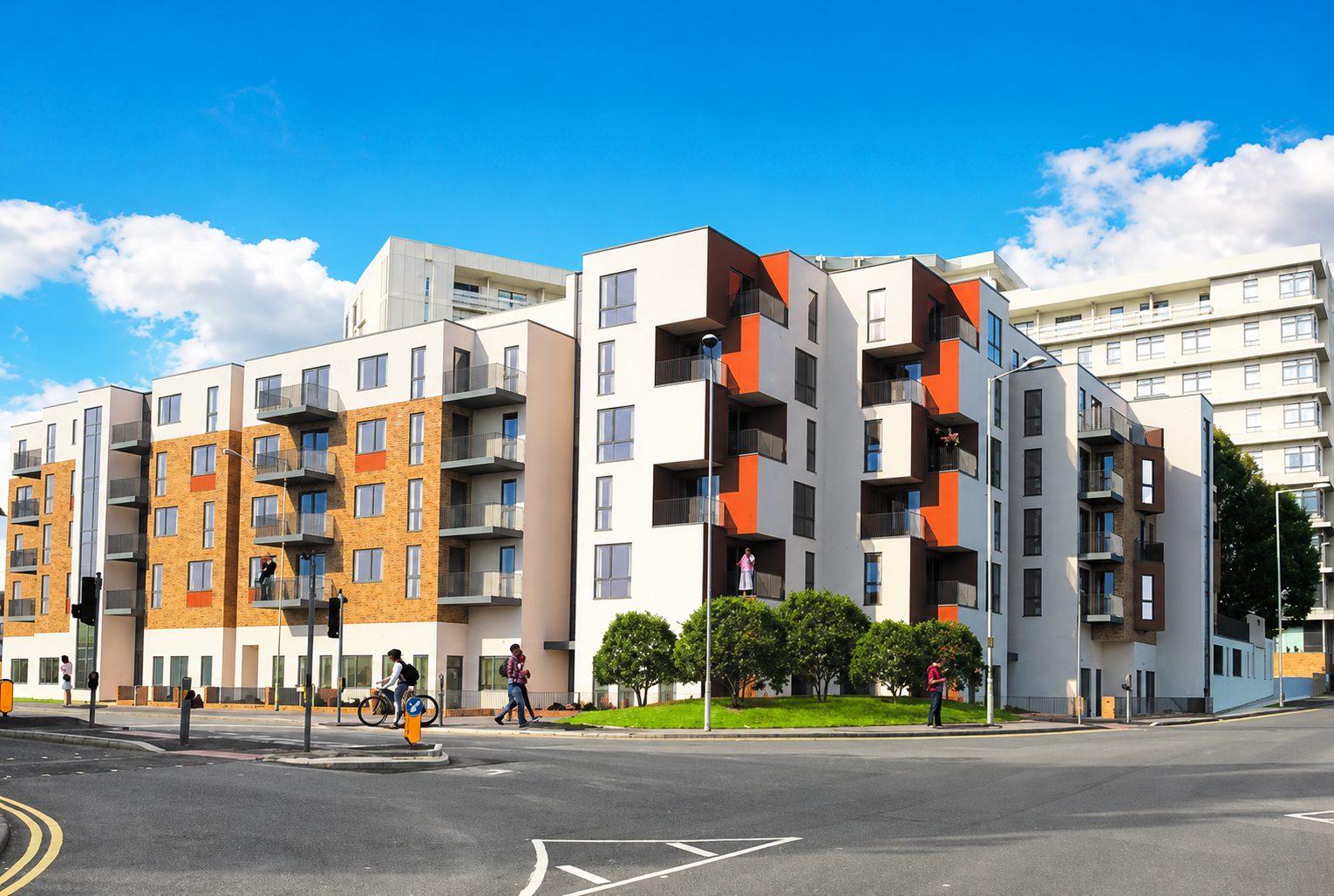 Design visual of a white and orange-panelled apartment wing on a street corner, the Panorama tower behind